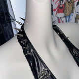 Top de cuero sintético con cuello halter, cordones y apliques de calavera con cadena metálica 